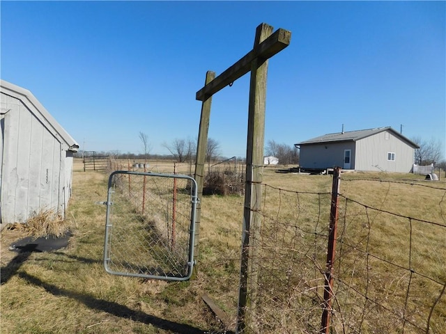 view of yard featuring a gate, a rural view, and fence