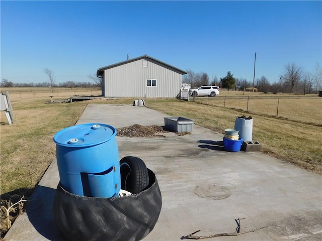 exterior space with a rural view, an outdoor structure, and fence