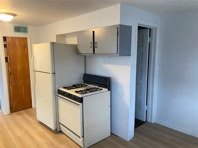 kitchen with baseboards, visible vents, white gas stove, gray cabinetry, and light wood-style floors