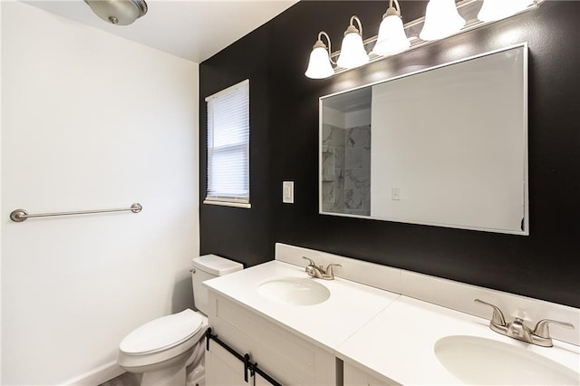 bathroom featuring double vanity, toilet, and a sink