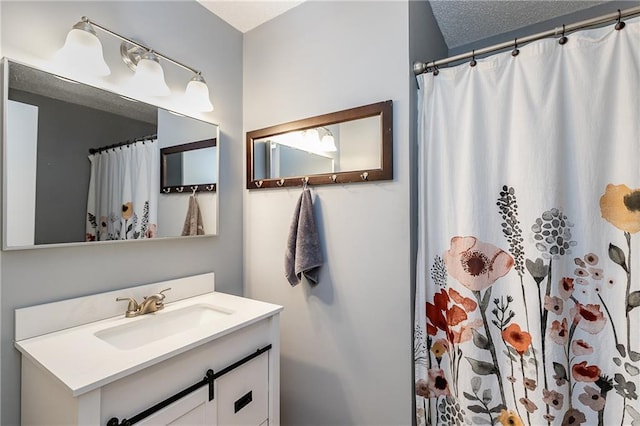 full bath with curtained shower, a textured ceiling, and vanity