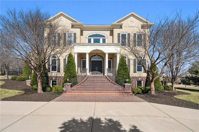 view of front of house featuring brick siding and stucco siding