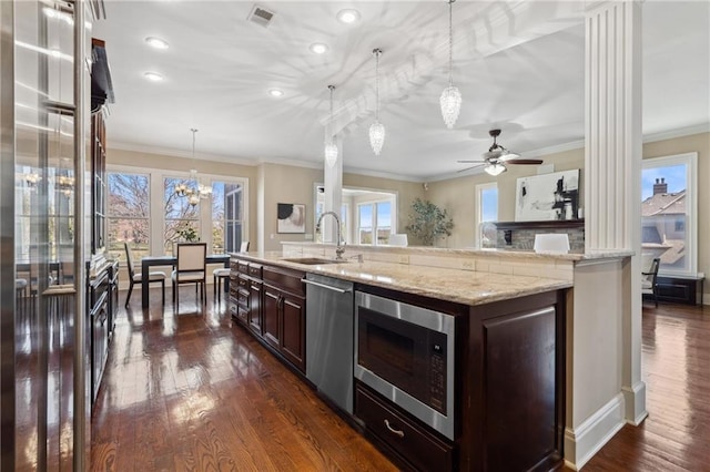 kitchen featuring dark wood-style floors, appliances with stainless steel finishes, crown molding, and a sink