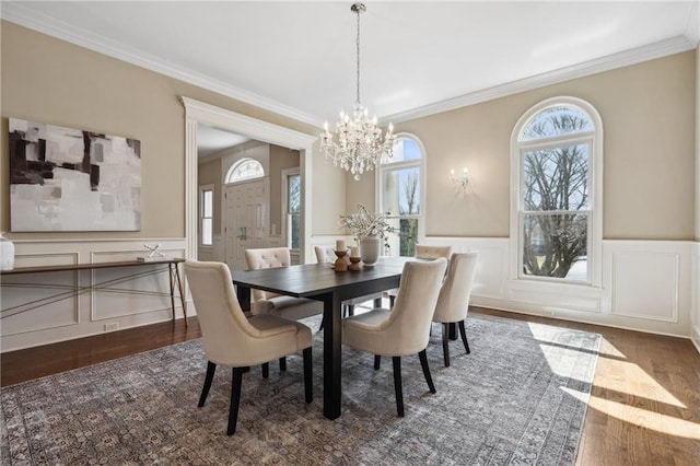 dining area with a wealth of natural light, an inviting chandelier, and wood finished floors