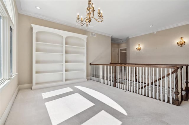 spare room with visible vents, carpet floors, a notable chandelier, and crown molding