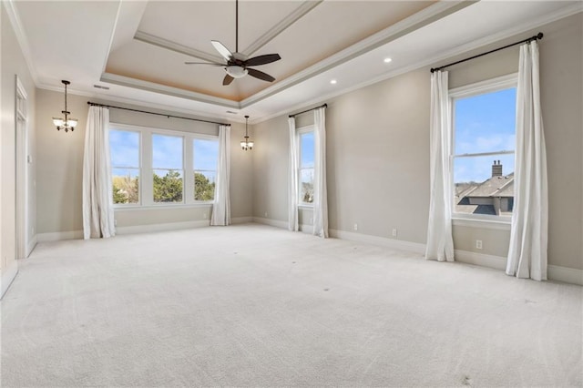 carpeted spare room featuring baseboards, a tray ceiling, recessed lighting, crown molding, and ceiling fan with notable chandelier