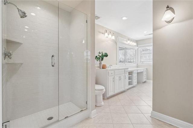 bathroom with tile patterned floors, a shower stall, vanity, and baseboards