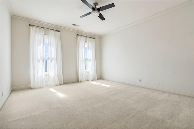 carpeted empty room featuring visible vents, baseboards, crown molding, and ceiling fan