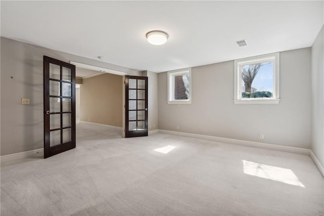 carpeted spare room featuring visible vents, french doors, and baseboards