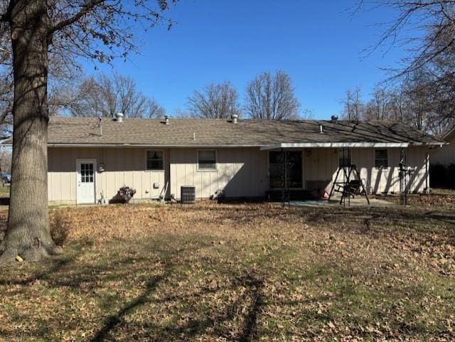 back of property with a patio area, board and batten siding, and central AC