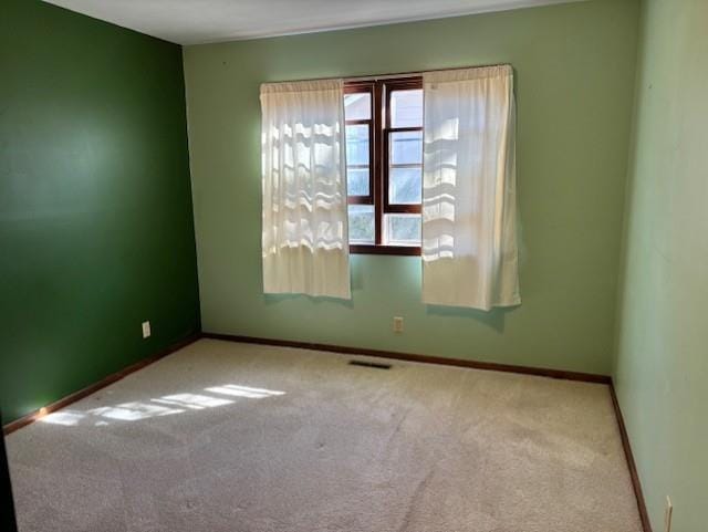 unfurnished room featuring baseboards and carpet floors