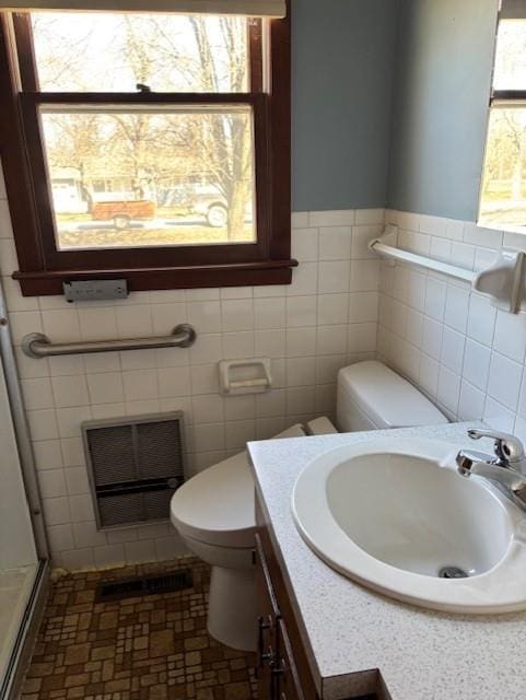 bathroom featuring vanity, toilet, visible vents, and a stall shower