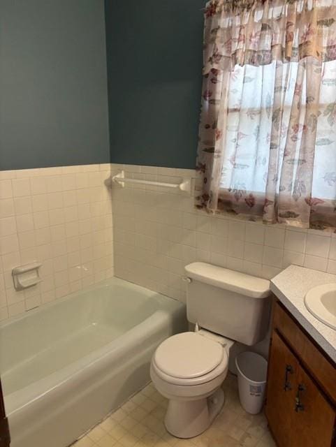 bathroom featuring a washtub, toilet, tile walls, and vanity