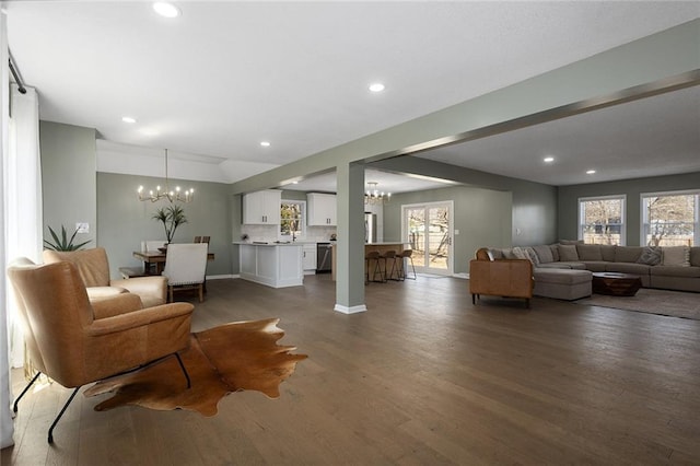 living area with a wealth of natural light, recessed lighting, an inviting chandelier, and wood finished floors