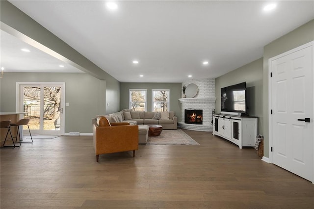 living room featuring a fireplace, recessed lighting, dark wood-style floors, and baseboards