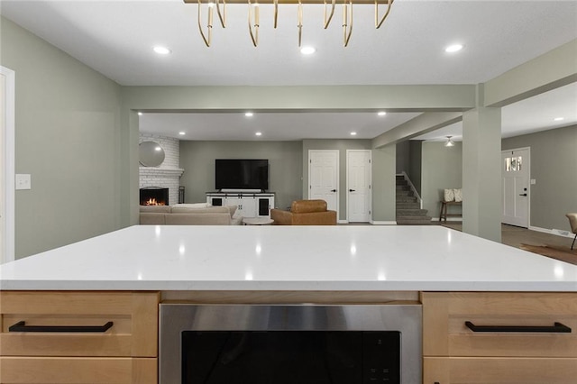 kitchen with open floor plan, recessed lighting, a fireplace, and light countertops