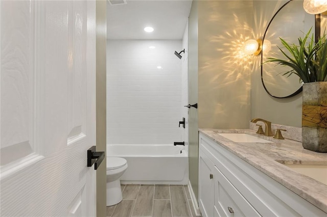 bathroom featuring wood tiled floor, toilet, shower / bath combination, double vanity, and a sink