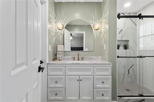 bathroom with a marble finish shower and vanity