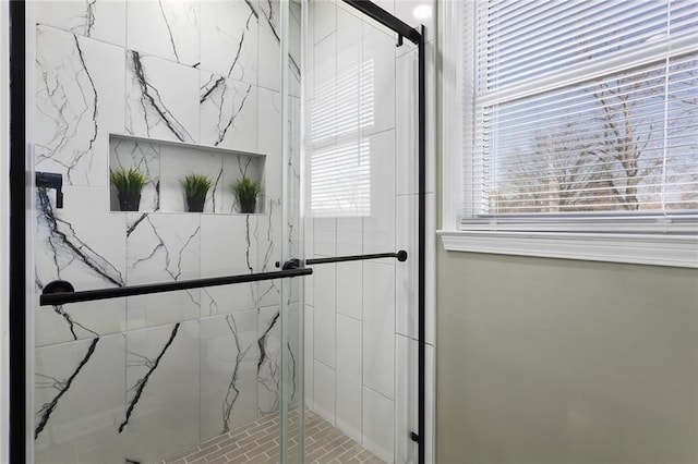 bathroom featuring a marble finish shower