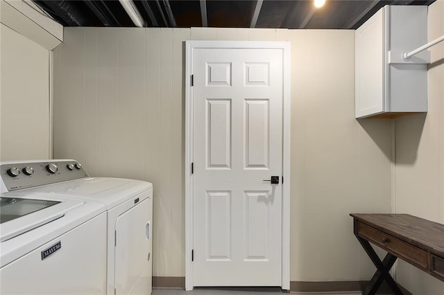 clothes washing area with cabinet space and independent washer and dryer