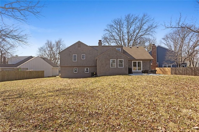 rear view of house featuring a yard, a patio, a chimney, and fence