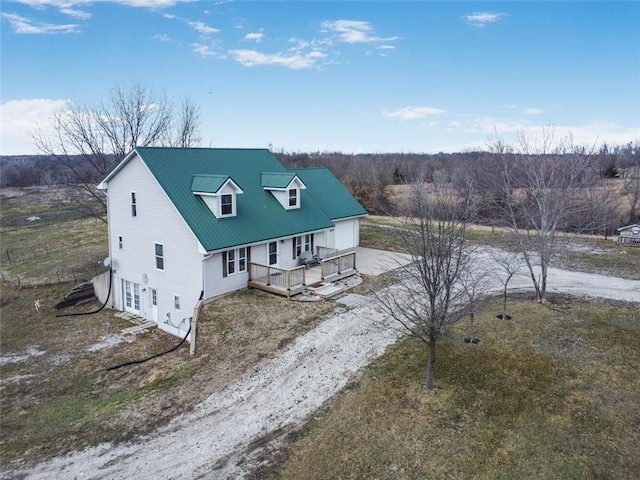 view of front of house with a garage, metal roof, and driveway