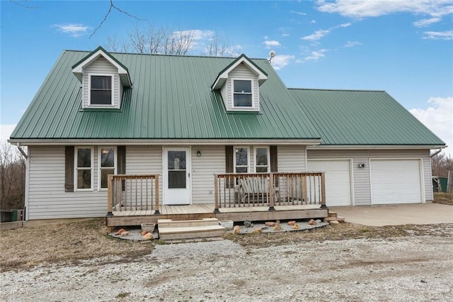 new england style home featuring a wooden deck, driveway, metal roof, and a garage