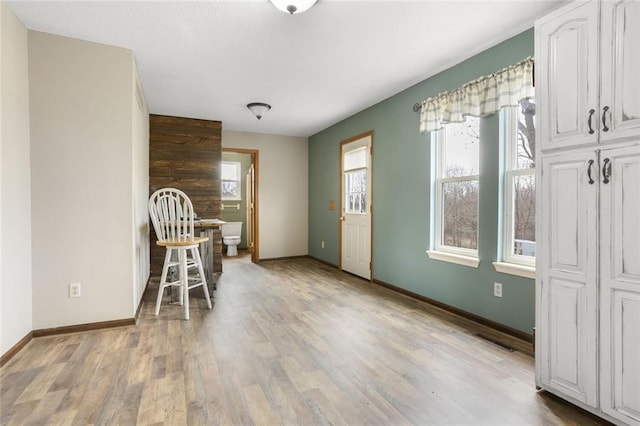 dining space with visible vents, baseboards, and light wood-style flooring