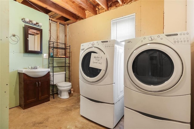 laundry area featuring washing machine and clothes dryer and a sink