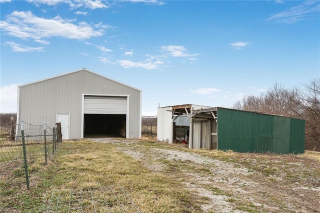 view of pole building featuring fence and driveway