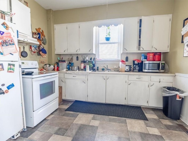 kitchen featuring under cabinet range hood, a sink, white cabinetry, white appliances, and light countertops