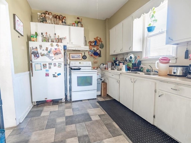 kitchen featuring under cabinet range hood, a sink, white appliances, white cabinets, and light countertops