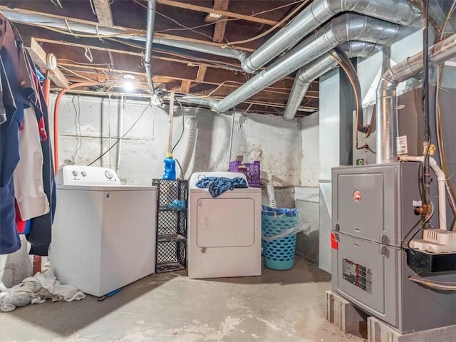 unfinished basement with heating unit and washer and clothes dryer