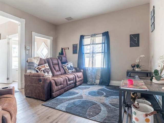 living area featuring visible vents and wood finished floors