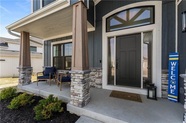 entrance to property featuring stone siding and covered porch