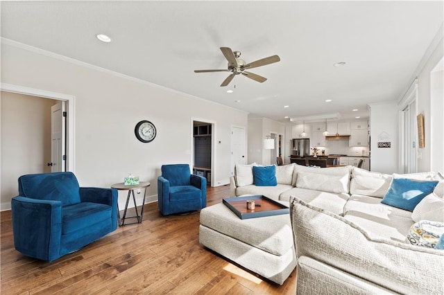 living room featuring ceiling fan, recessed lighting, light wood-style flooring, and crown molding