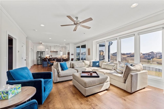 living area featuring recessed lighting, light wood-style flooring, a ceiling fan, and ornamental molding