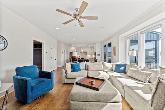 living room featuring recessed lighting, wood finished floors, baseboards, and ornamental molding