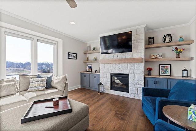 living room with baseboards, a stone fireplace, dark wood finished floors, and crown molding