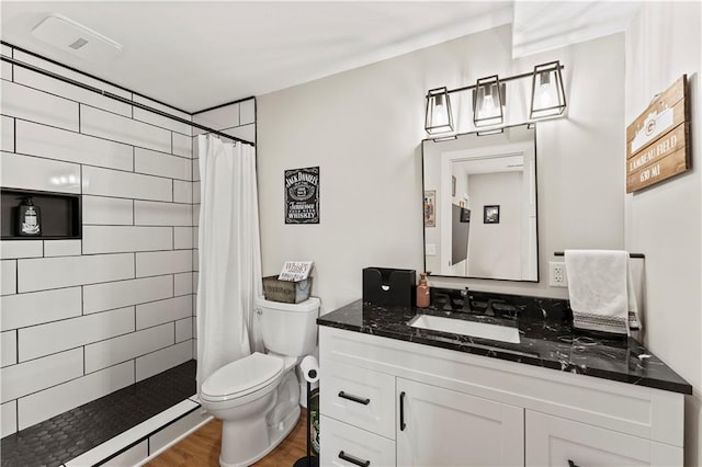 full bathroom featuring tiled shower, toilet, vanity, and wood finished floors