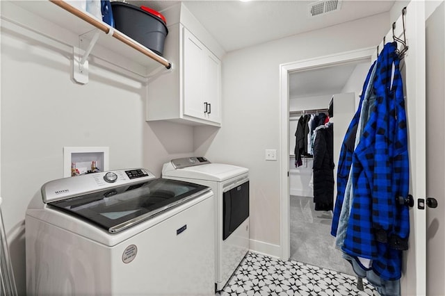 laundry area featuring visible vents, baseboards, washer and clothes dryer, light carpet, and cabinet space