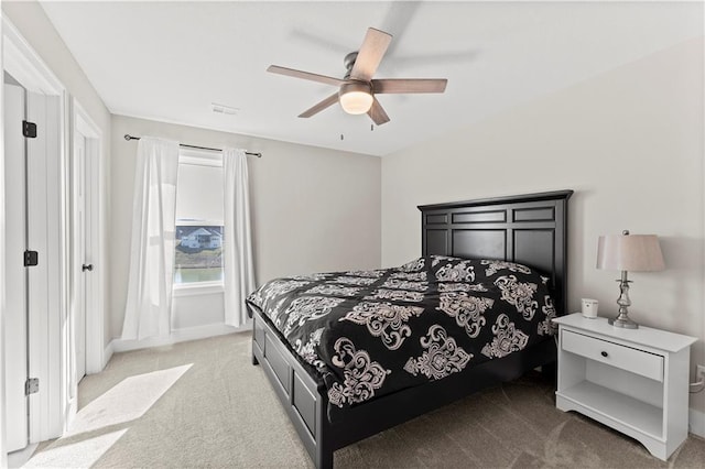 bedroom featuring baseboards, light colored carpet, and ceiling fan