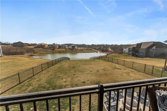 view of yard featuring a residential view, a fenced backyard, and a water view