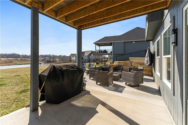 view of patio / terrace featuring grilling area, an outdoor living space, and a water view