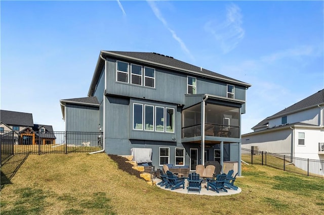 rear view of property with a fenced backyard, an outdoor fire pit, a yard, a sunroom, and a patio area