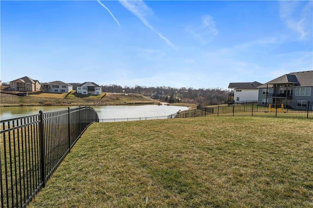 view of yard with a residential view, a fenced backyard, and a water view