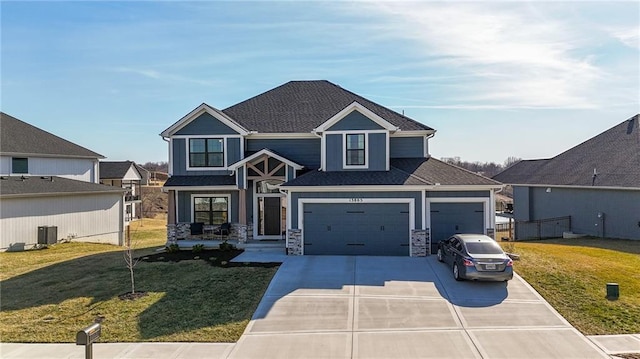 craftsman house featuring a front lawn, concrete driveway, a garage, and central AC