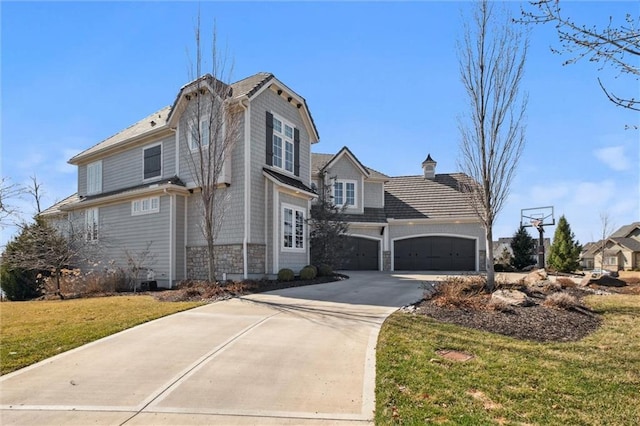 16121 Paradise St, Overland Park, KS 66221 - view of front of house with a front yard, driveway, an attached garage, and stone siding