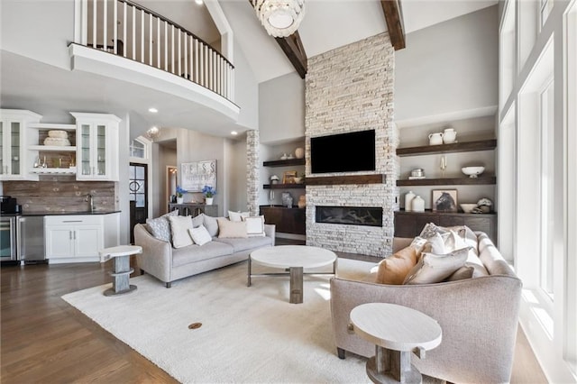 16121 Paradise St, Overland Park, KS 66221 - living room with a fireplace, dark wood-style floors, a towering ceiling, beam ceiling, and bar area
