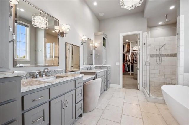 16121 Paradise St, Overland Park, KS 66221 - bathroom featuring a stall shower, vanity, a freestanding bath, a spacious closet, and a chandelier